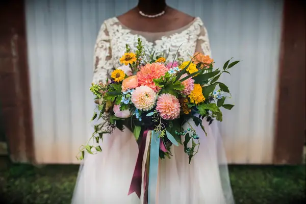Bride holding colorful dahlia bouquet 