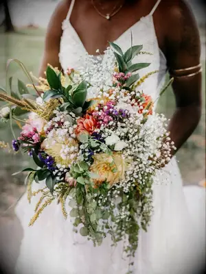 Bride holding wildflower bouquet with baby