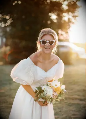Bride wearing sunglasses and holding bouquet