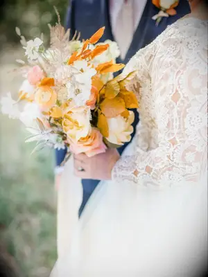 bride holding orange bouquet