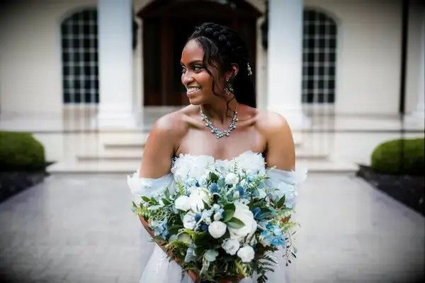 Bride in off-the-shoulder dress holding bouquet 