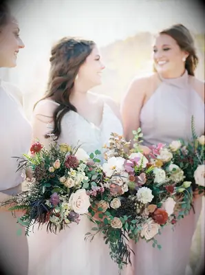bride and bridesmaids posing together and holding bouquets