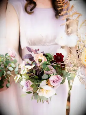 Bridesmaid in purple dress holding bouquet