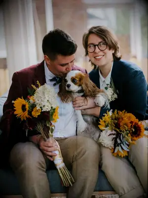 Brides holding dog and sunflower bouquets