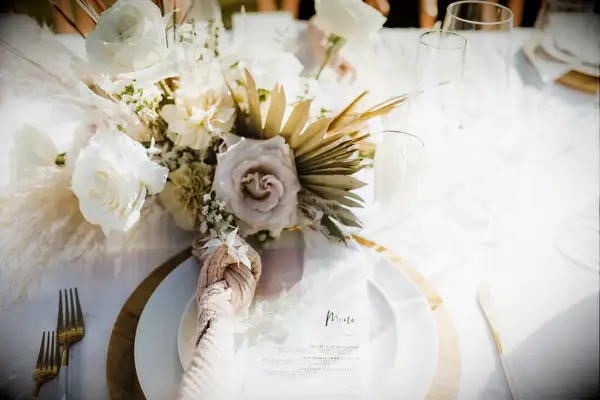 A gorgeous boho table arrangement of dried flowers and fresh roses.