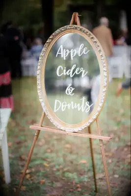 A mirror sits on a wooden easel, with chalk writing declaring what