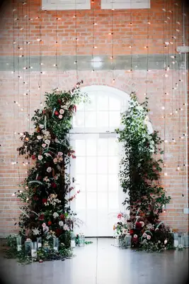 Floral arrangements frame the natural light streaming through this arched window.