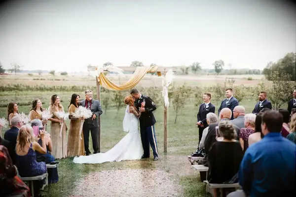 A bride and groom lean in for a kiss at this outdoor wedding ceremony.