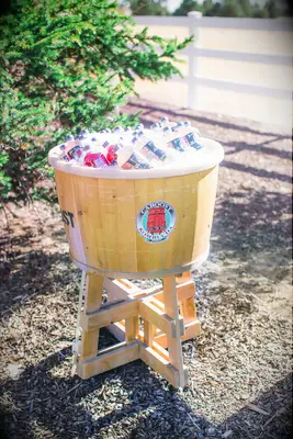 wooden barrel bucket with bottles of kombucha in ice