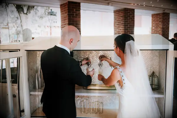 bride and groom pouring beer from tap on mobile bar truck 