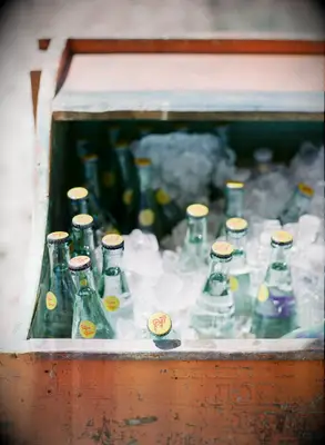 wooden crate with bottles of topo chico water in ice