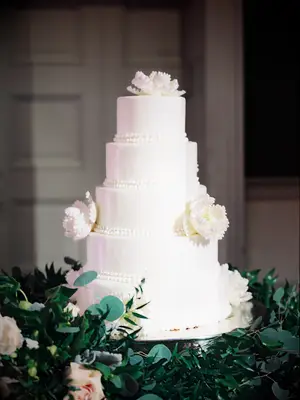 white five-tier wedding cake with beading trim