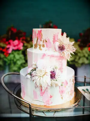 spackled wedding cake with pink and gold watercolor design