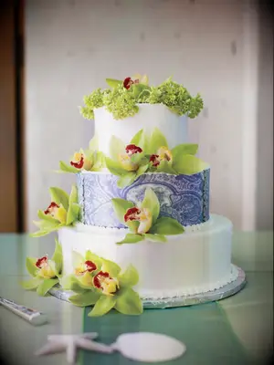 three tier fondant wedding cake with blue stencil middle tier and green orchids