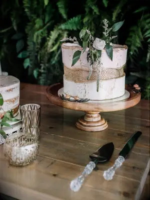 one-tier wedding cake on wooden stand with crystal cake knife and serving set