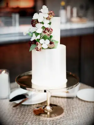 two-tier white fondant wedding cake on rose gold stand