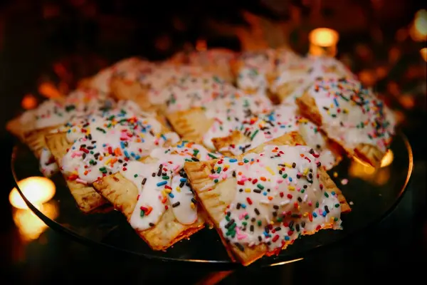 Homemade pastries topped with icing and colorful sprinkles. 