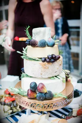 Cheese wheels stacked on a tower to resemble a tiered wedding cake. 