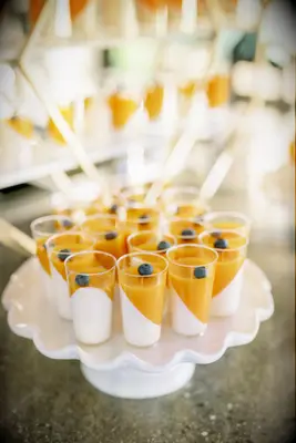 Mini panna cotta shooters on display on a dessert table. 