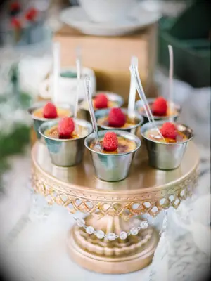 Individual portions of creme brulee arranged on a cake stand. 
