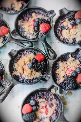 Mini portions of berry cobbler in cast-iron skillets. 