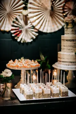 Dessert table featuring chocolate-dipped marshmallows on a stick. 