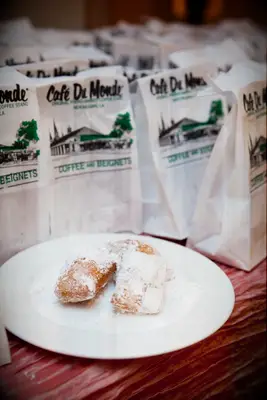 Plate of freshly cooked beignets topped with powdered sugar. 