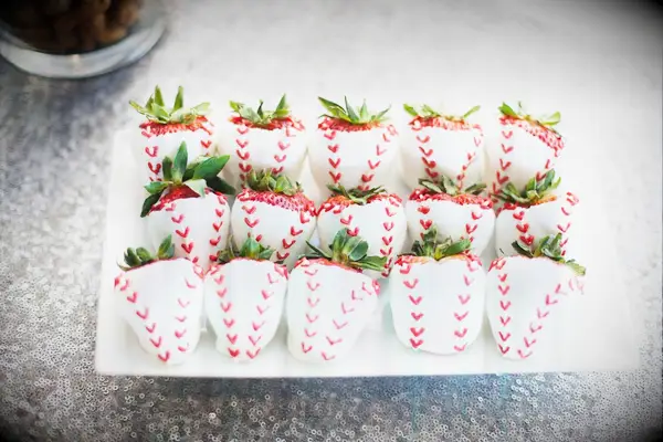 White-chocolate dipped strawberries with baseball stitching. 