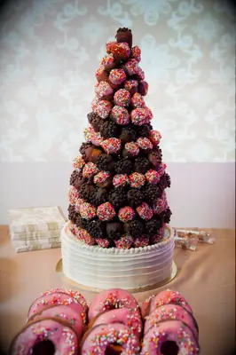 Donut hole tower displayed on a dessert table. 