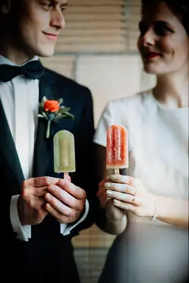 Couple holds colorful popsicles. 