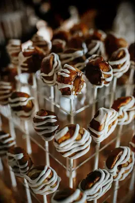 Mini cinnamon rolls on sticks displayed on a dessert table. 