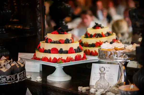 Three-tiered cheesecake displayed on a dessert table. 
