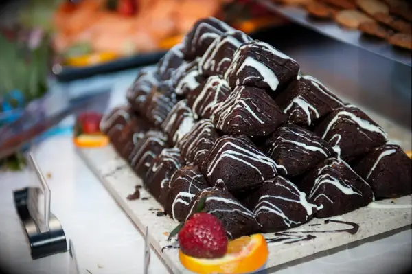 Tray of chocolate brownies with a white chocolate drizzle. 