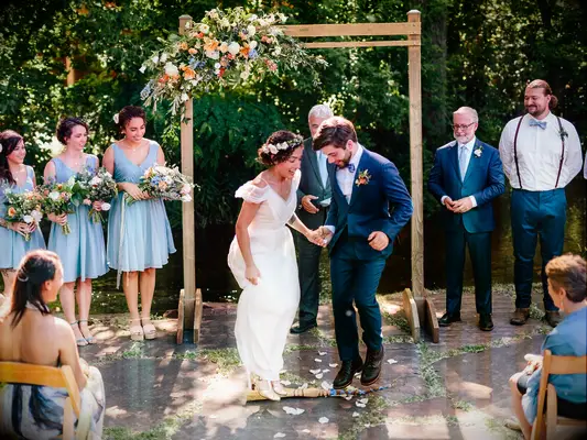 Couple jumping the broom at wedding