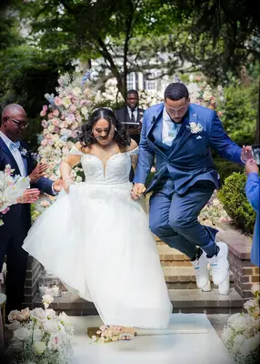 Couple jumping the broom at wedding