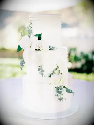 Three-Tier White Wedding Cake With Combed Buttercream and White Flowers