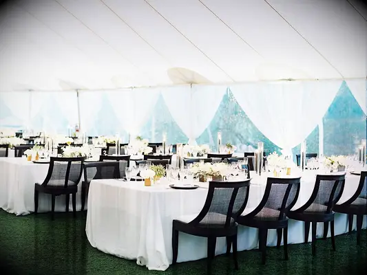 Tented wedding reception with black chairs