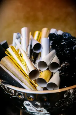 silver and gold noisemakers in a metallic silver bowl at new year