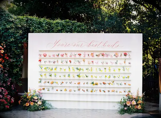 Botanical escort card display at summer wedding