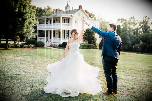 Couple dancing outside on the manicured ground with the venue in the background