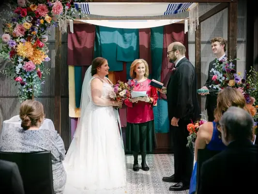 Couple exchanging Jewish wedding vows under chuppah