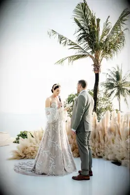 Bride in Gold Crown, Off-the-Shoulder Lace Gown Reading Vows to Groom, Pampas Grass Ceremony on Water