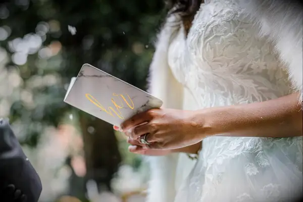 Bride Holding Gray-and-Gold Vow Book During Elopement at the Anderson House in Washington, DC