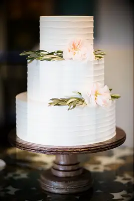 three tier white buttercream wedding cake with flowers