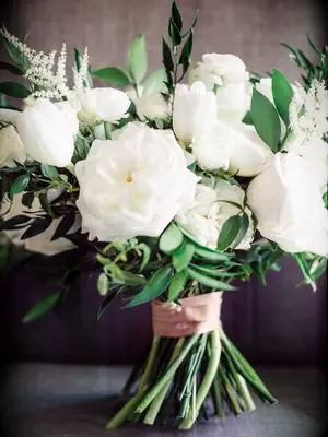 classic wedding bouquet with white roses, tulips, astilbe and greenery with stems wrapped in blush ribbon