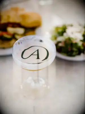 cocktail in coupe glass with monogrammed edible drink topper