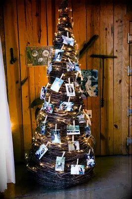 Christmas tree made of twigs adorned with pictures and lights.