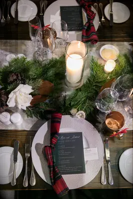 Christmas tablescape with plaid napkins and pine garlands. 