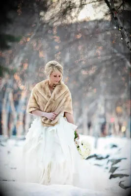 Bride wearing fur stole in a snow wedding photo shoot.
