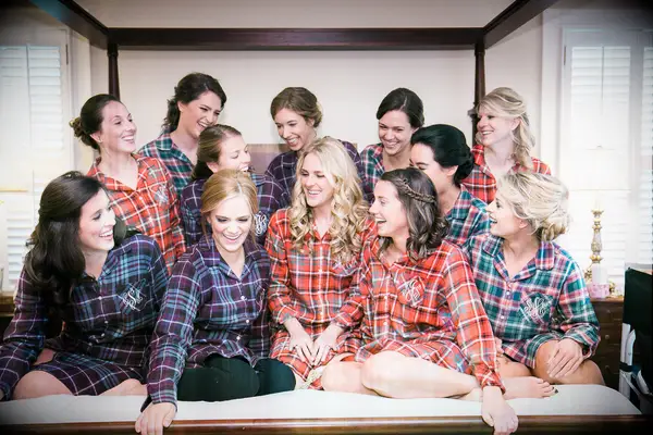 Bride and bridesmaids wearing plaid getting ready pajamas.